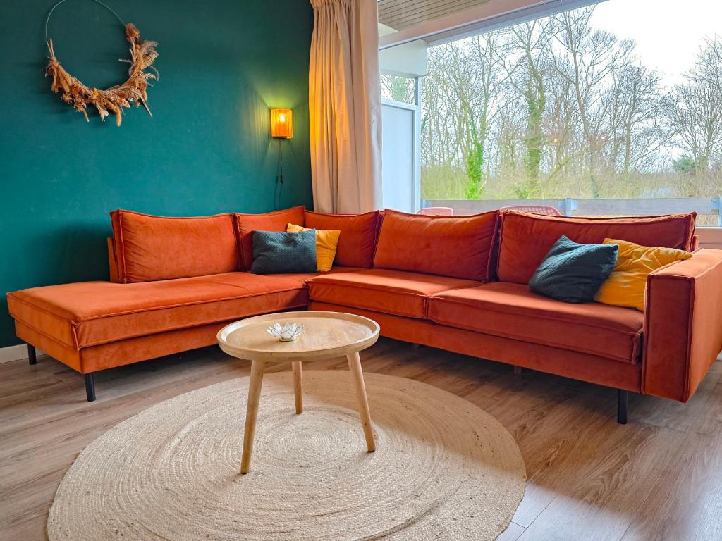 an orange couch in a living room with a table at Vakantie appartement Chava WE09 in Westkapelle