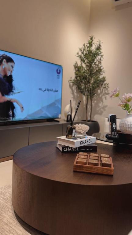 a round table with a tv in a room at ZA apartment in Al Ahsa
