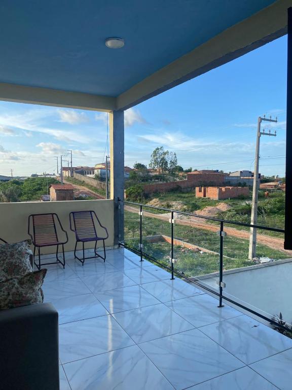 a balcony with two chairs and a large window at Ramos hotel in Barreirinhas