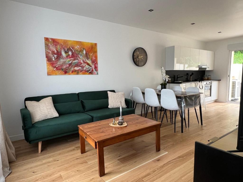 a living room with a green couch and a table at Maison de ville à Etampes in Étampes