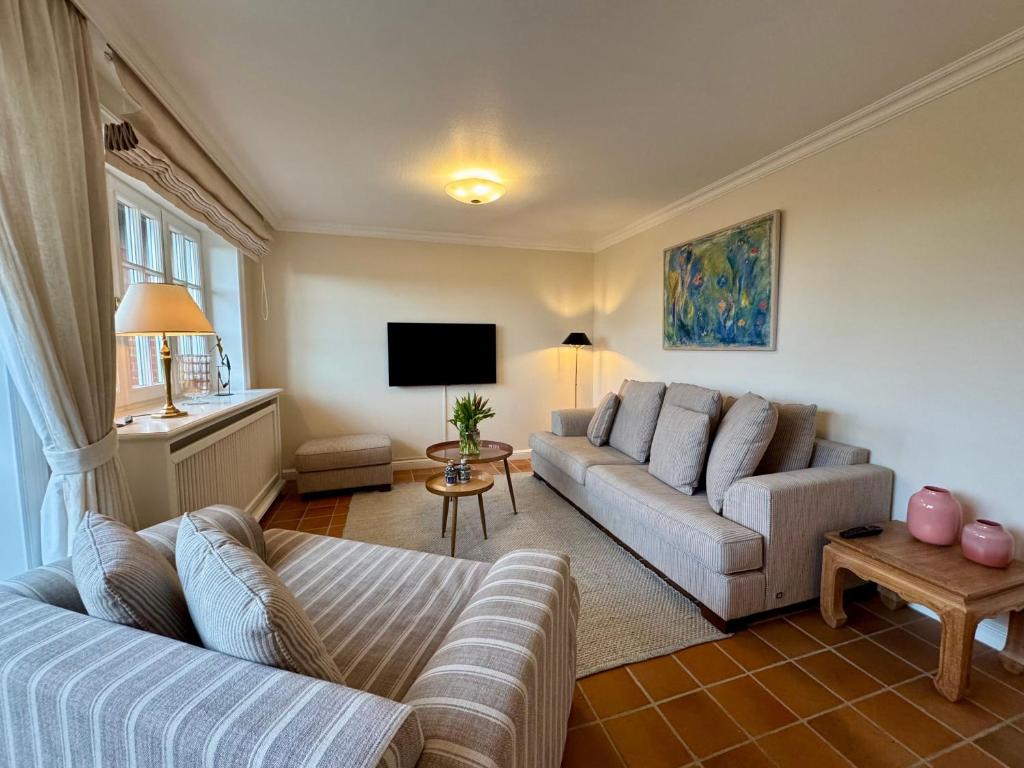 a living room with two couches and a tv at Landhaus-Duenenhof in Rantum