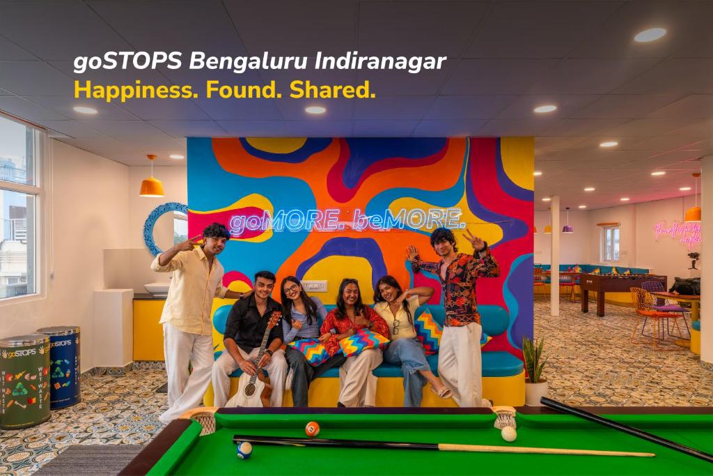 a group of people standing next to a pool table at goSTOPS Bengaluru, Indiranagar - Private Rooms & Dorms in Bangalore