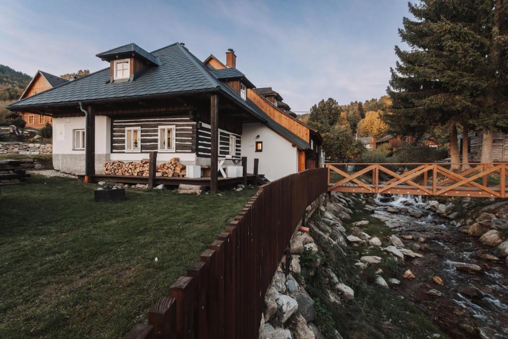 a small house with a fence next to a river at Chaloupka Kunčice in Staré Město
