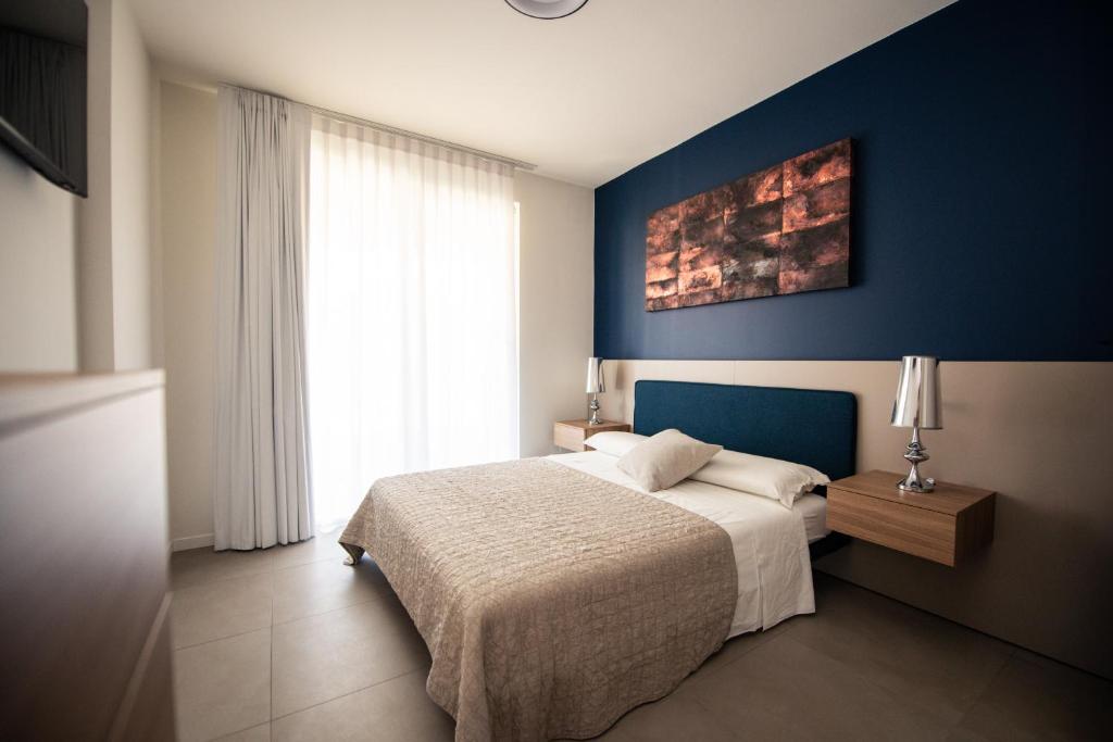 a bedroom with a bed and a blue wall at Maison Selva - Corte Brunati Villetta Deluxe con piscina e garage in Salò