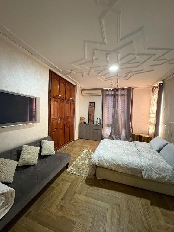 a large bedroom with a bed and a couch at Appartement plein centre marrakech p in Marrakesh