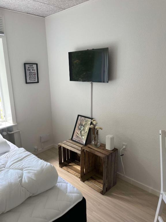 a bedroom with a bed and a tv on the wall at Billund mini hostel room 3 in Billund