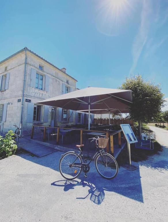 a bike parked under an umbrella at a table at Hotel Napoleon in Île dʼAix