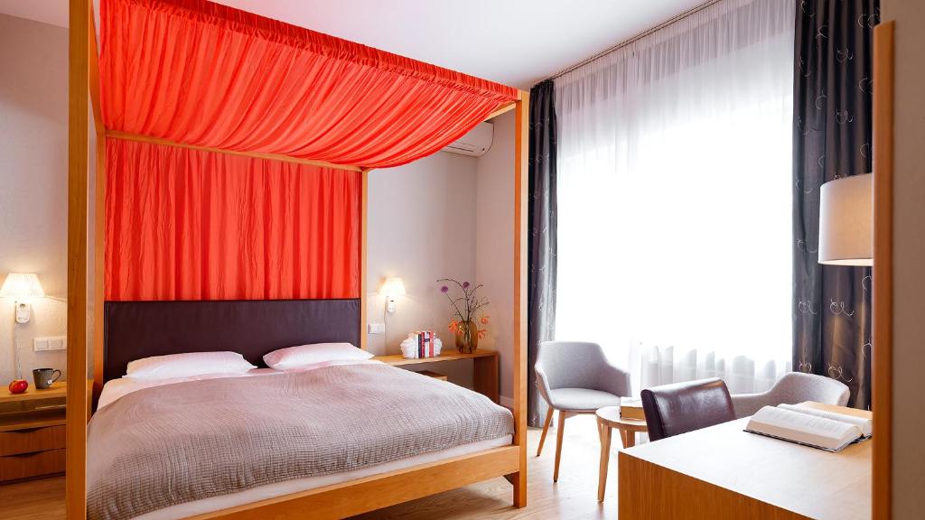 a bedroom with a bed with an orange canopy at BIO-Hotel Villa Orange in Frankfurt
