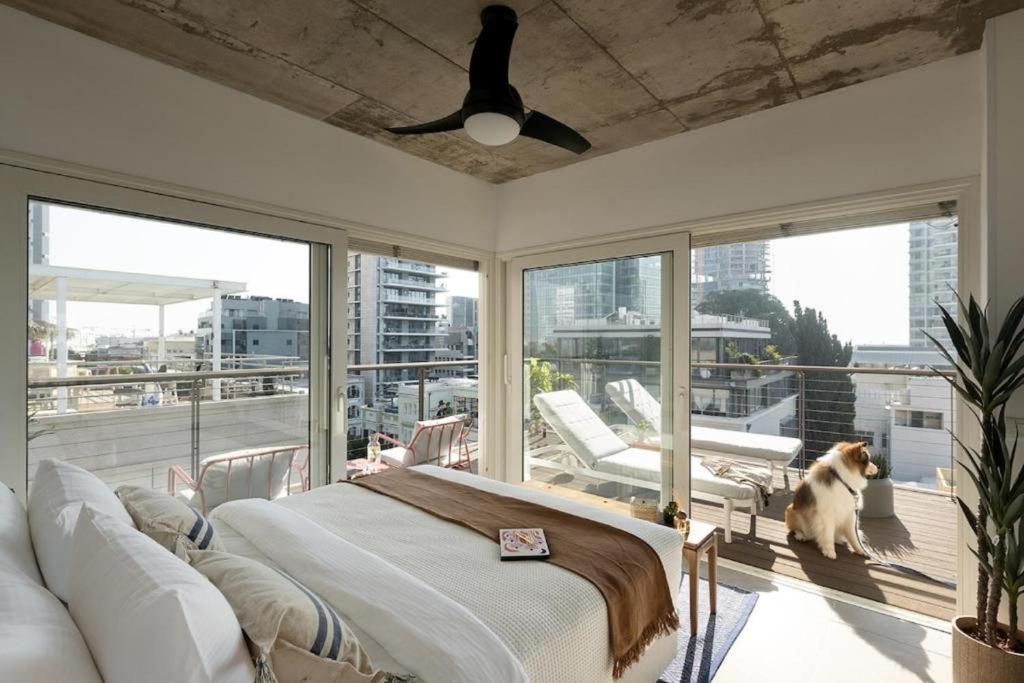 a bedroom with a bed and a dog sitting on a balcony at Mr Rothschild By TLV2GO in Tel Aviv
