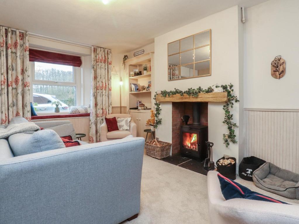 a living room with a blue couch and a fireplace at Willow Wood in Settle