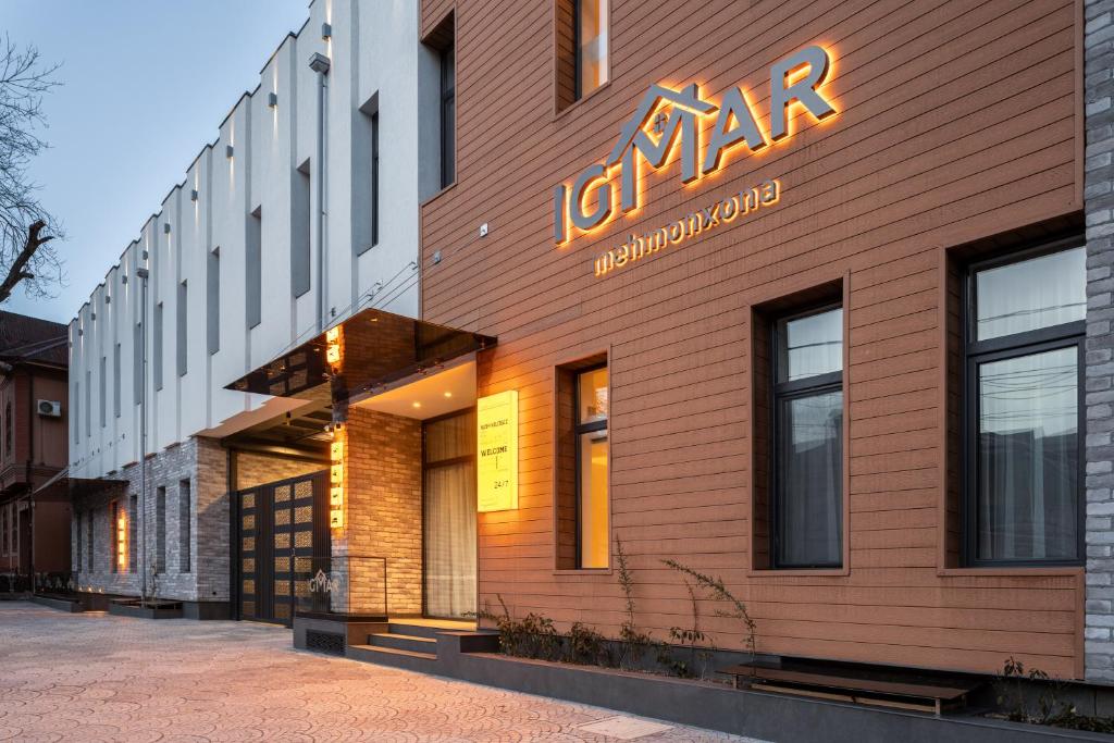 a building with a neon sign on the side of it at IGMAR Villas & Aparts Hotel in Tashkent