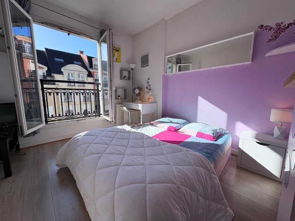 a bedroom with a bed and a purple wall at Paris Saint Maurice Montgolfier in Saint-Maurice