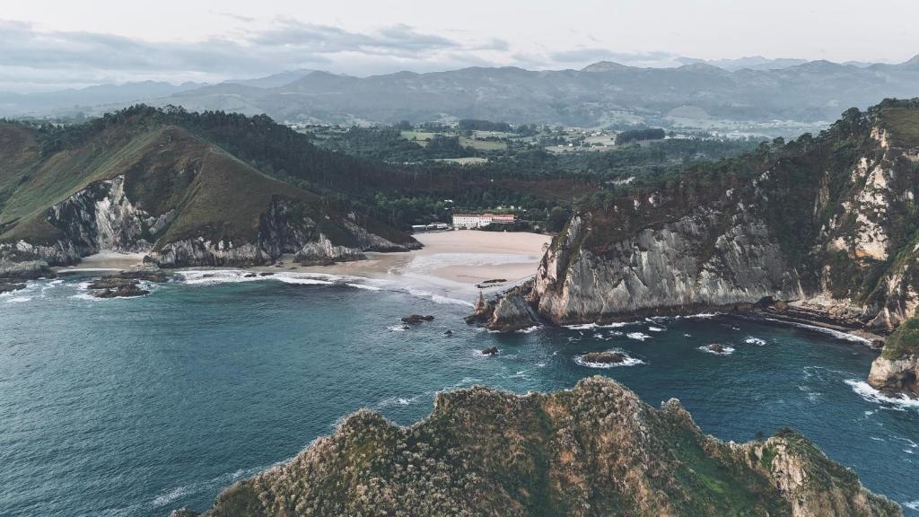 an aerial view of a beach with rocks in the water at HolaCamp la Franca in Las Conchas
