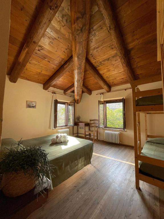 a bedroom with a bed in a room with wooden ceilings at B&B Agriturismo Montepolo in Canavaccio di Urbino