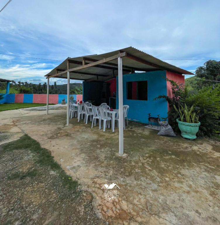 a table and chairs under a canopy in front of a house at Casarão Vale das Hortênsias in Bonito