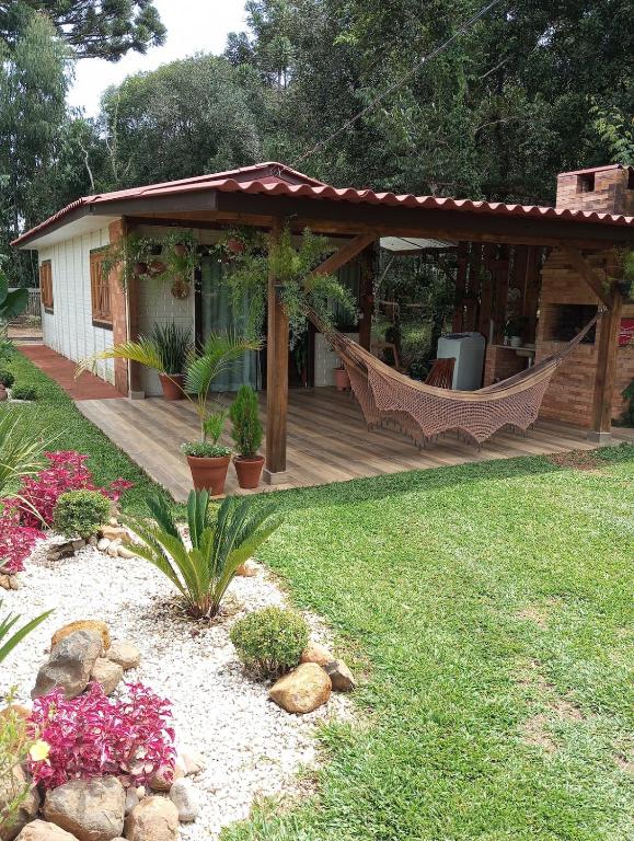 a house with a hammock in a yard at Cantinho do Sossego in Prudentópolis