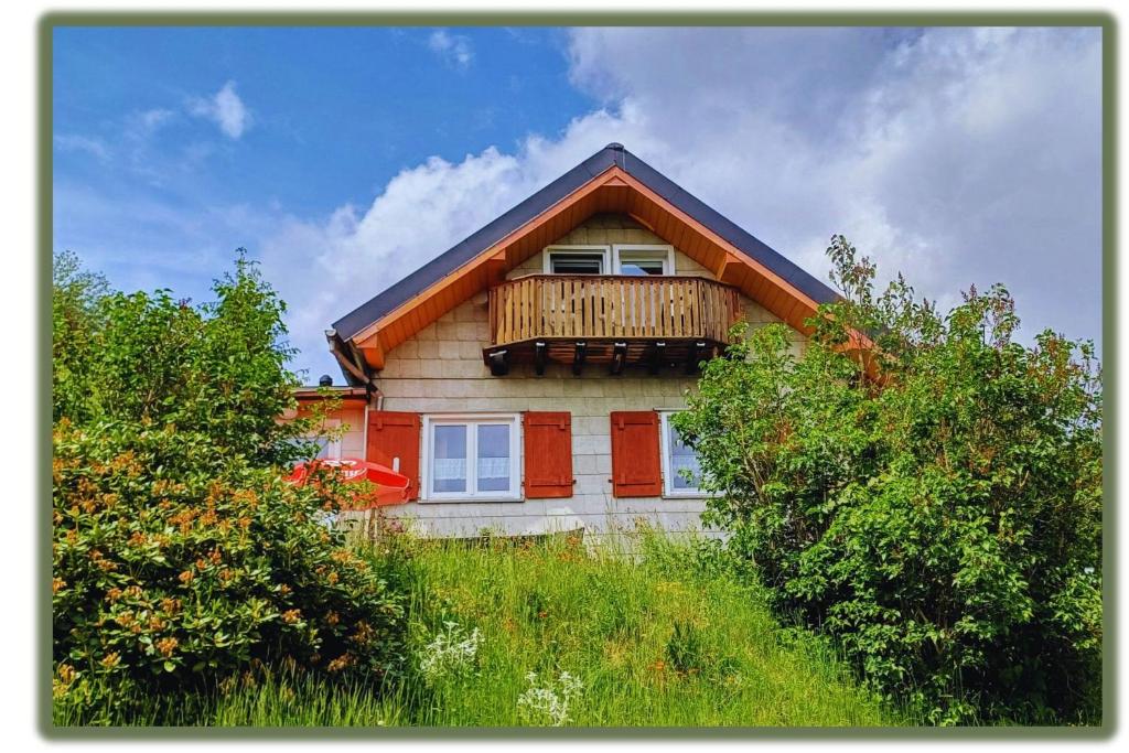 a house with a balcony on the side of it at Ferienhütte Ilmtalblick in Ilmenau
