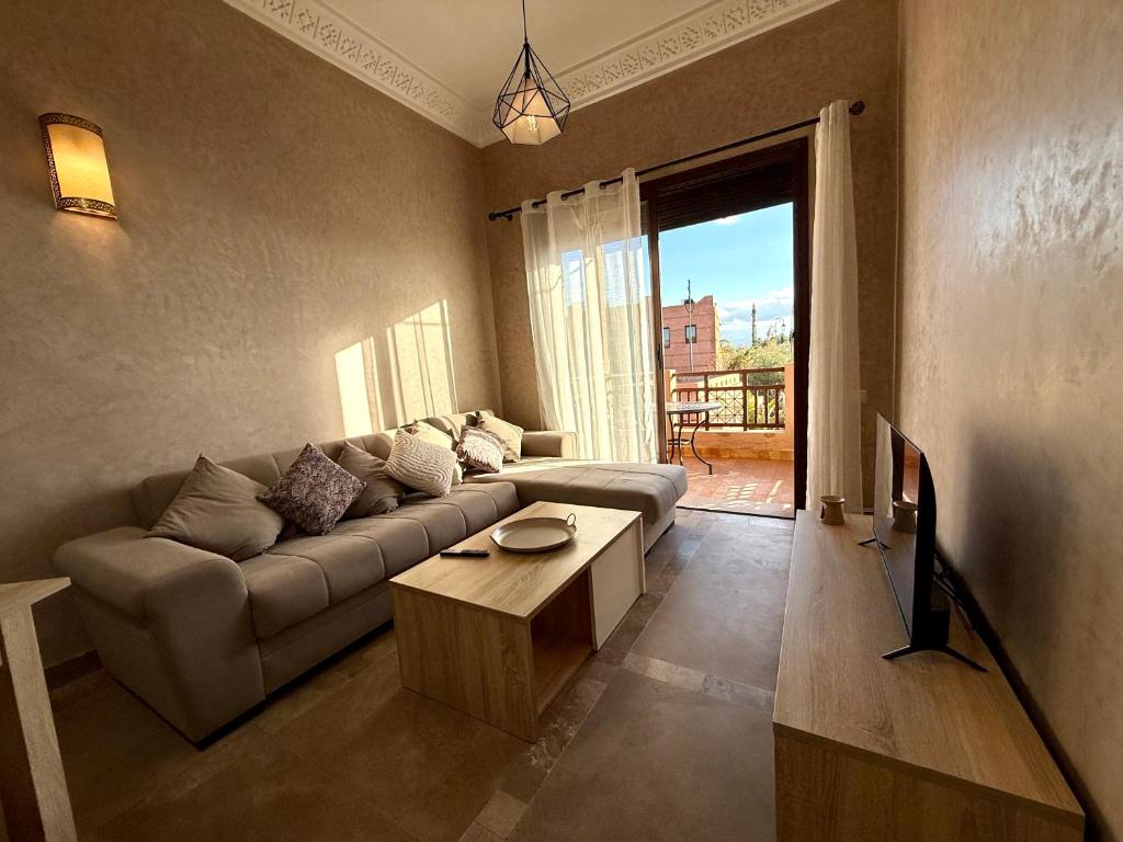 a living room with a couch and a table at Beach Mama Waky Marrakech Appartement Premium Piscine & Vue Atlas in Marrakesh
