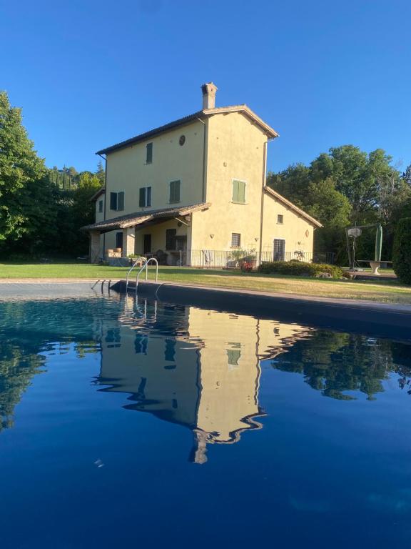 a house with a reflection in a pool of water at Luxury Villa Spoleto in Spoleto