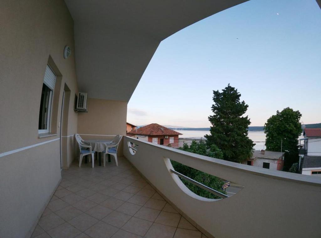 a balcony with a table and chairs in a building at Sanja Apartments Posedarje in Posedarje