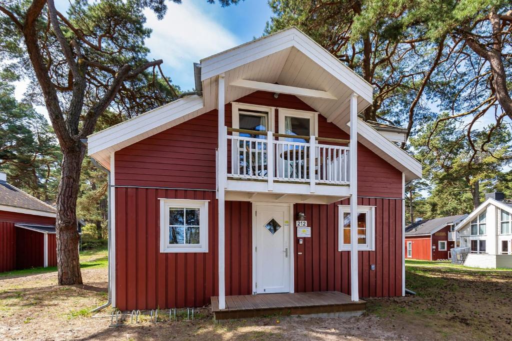 a red house with a balcony on top of it at Dünenblume - Baabe in Baabe