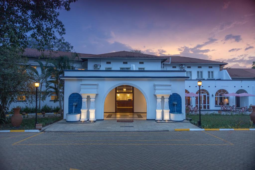 a large white building with a large doorway at Mount Elgon Hotel & Spa in Mbale