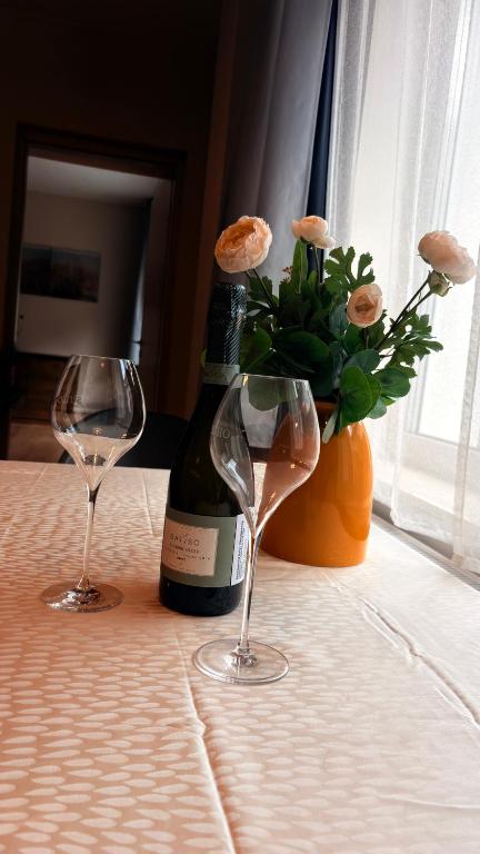 a bottle of wine and two glasses on a table at Castello Rosso Apartman in Pilisvörösvár
