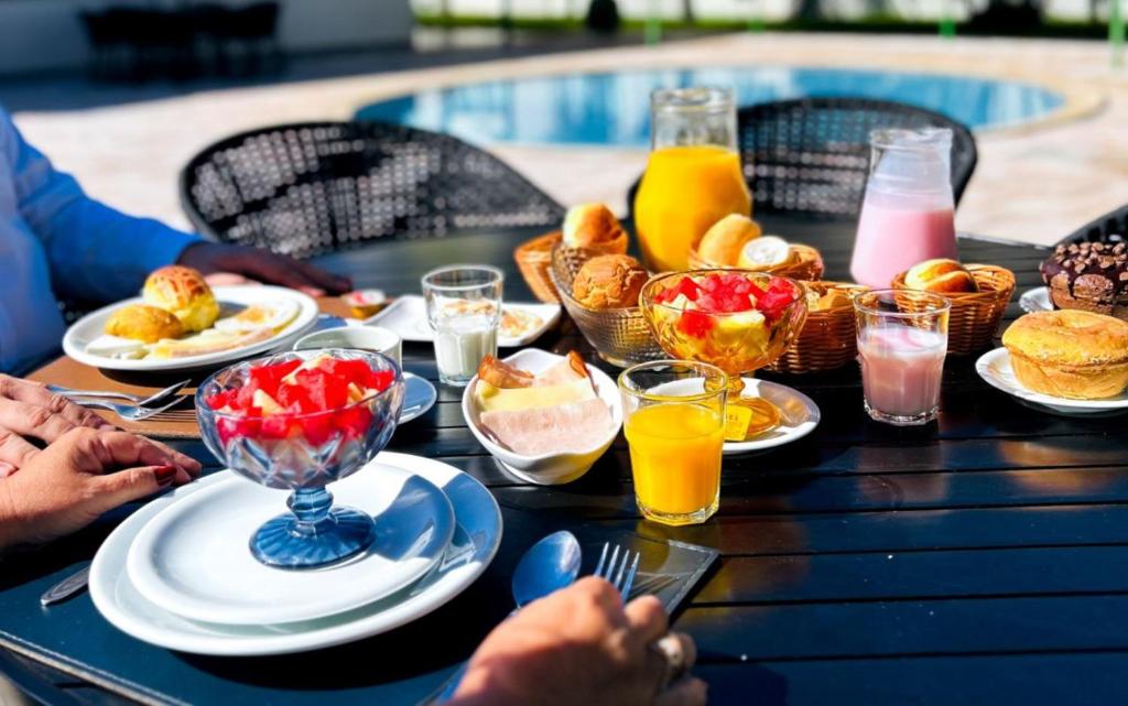 a table topped with plates of food and drinks at Hotel Dan Inn Uberaba & Convenções By Nacional Inn in Uberaba
