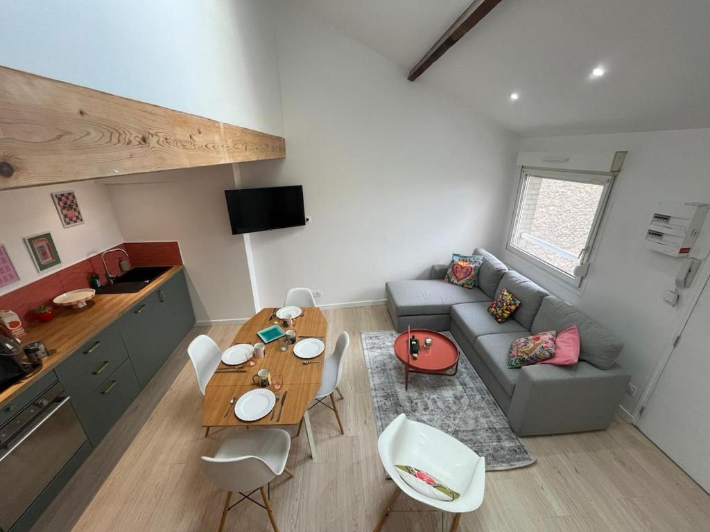 a living room with a couch and a table at Le cocon des Sacres in Reims