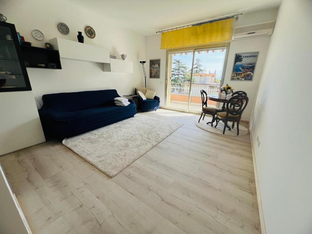 a living room with a blue couch and a table at Suite Semeria 466 - Sanremo in Sanremo