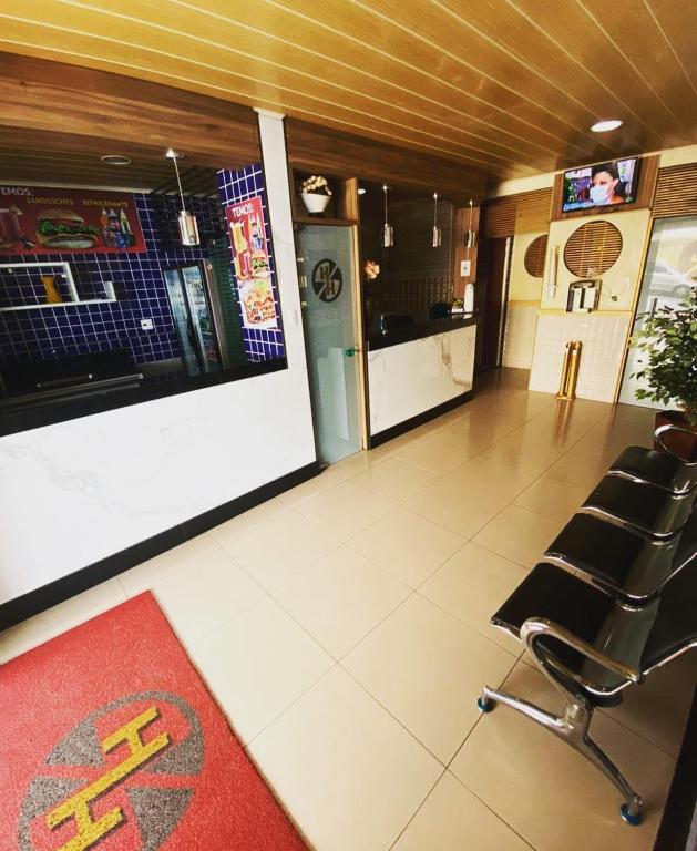 a waiting room with a chair and a counter at Hotel Hallas in Betim