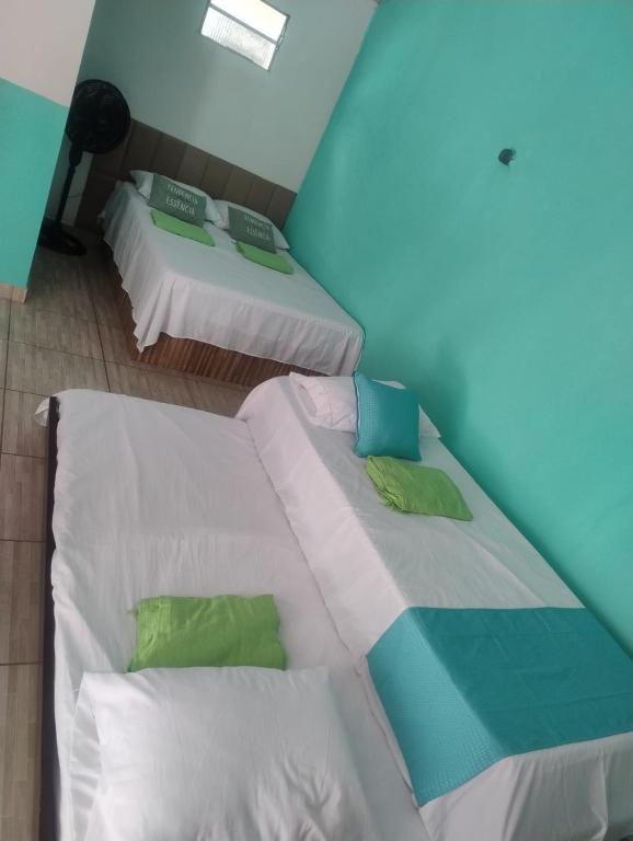 two twin beds in a room with a blue wall at Mar e Sol Tabatinga in Nísia Floresta