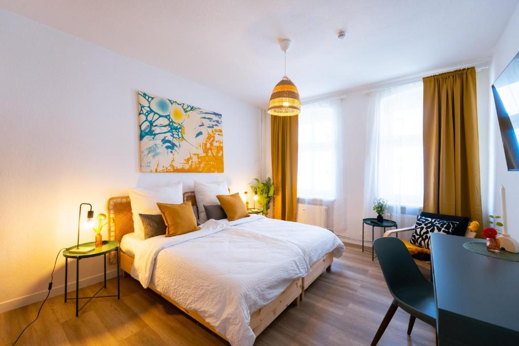 a bedroom with a bed and a table and chairs at BetterBeds Wilhelm City in Brandenburg an der Havel