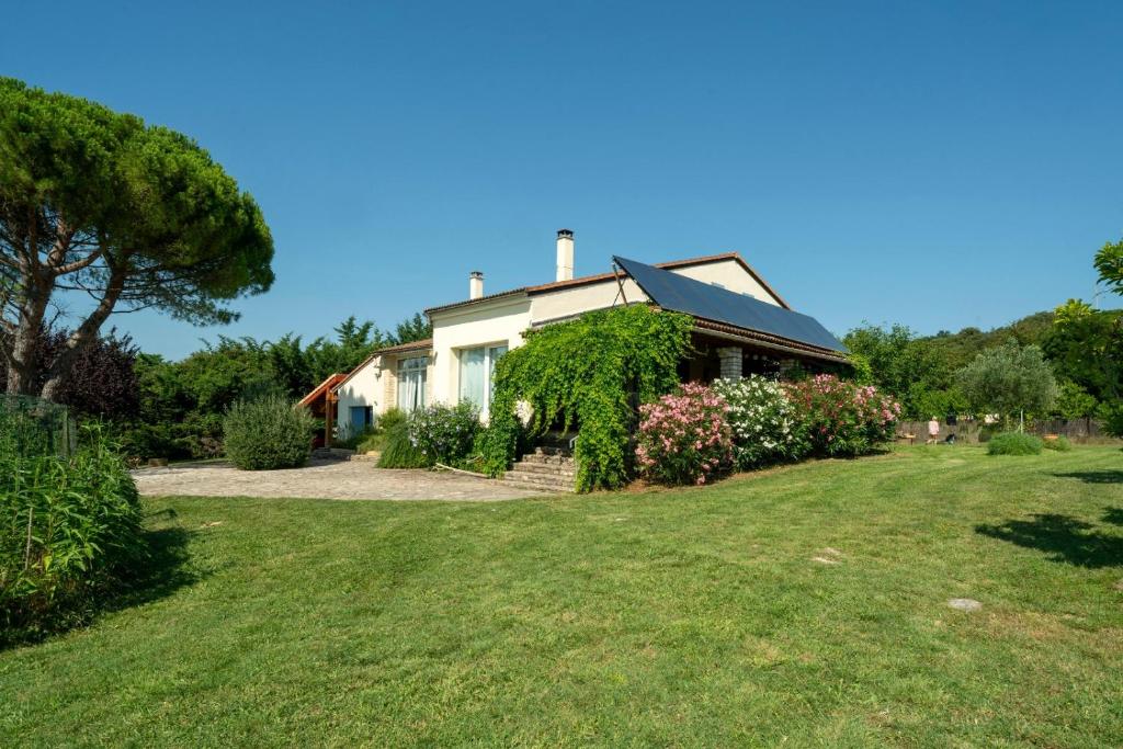 a house with a green yard in front of it at Le Petit Paradis in Labastide-de-Virac