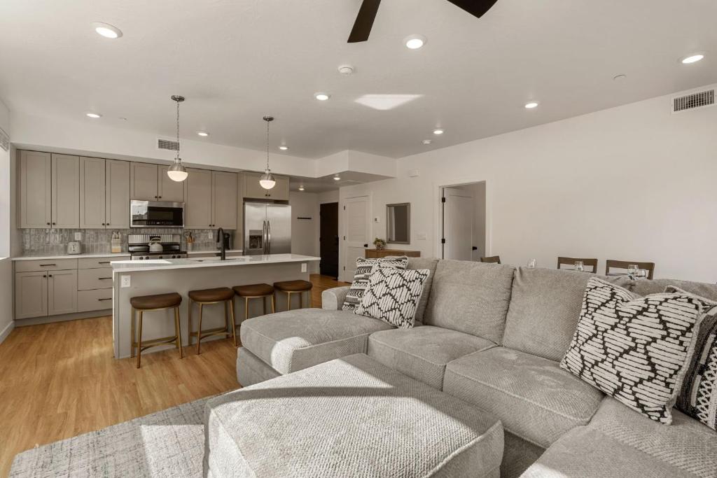 a living room with a couch and a kitchen at Ohana Nest condo in Hurricane