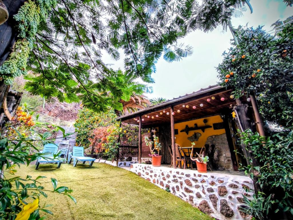 a house with a patio and chairs in a yard at Villa Tamadaba Rural Home - Pet Friendly, Near Ocean, Ideal for Long Stays in Agaete