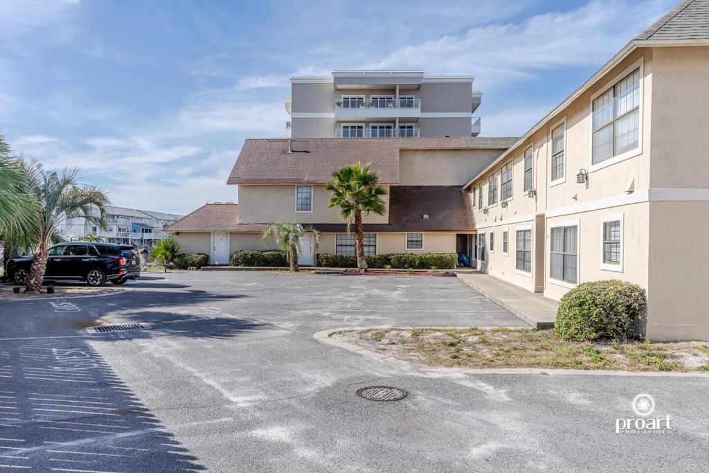a building with a parking lot in front of it at Nautical Costa Del Mar on Holiday Isle in Destin