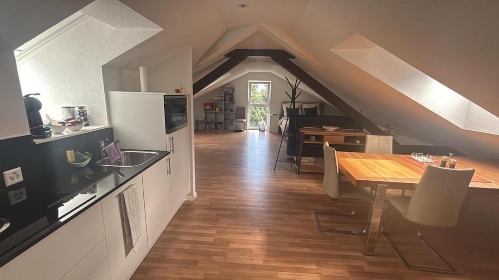 a kitchen with a table and a dining room at Bright attic apartment with charm in Sargans