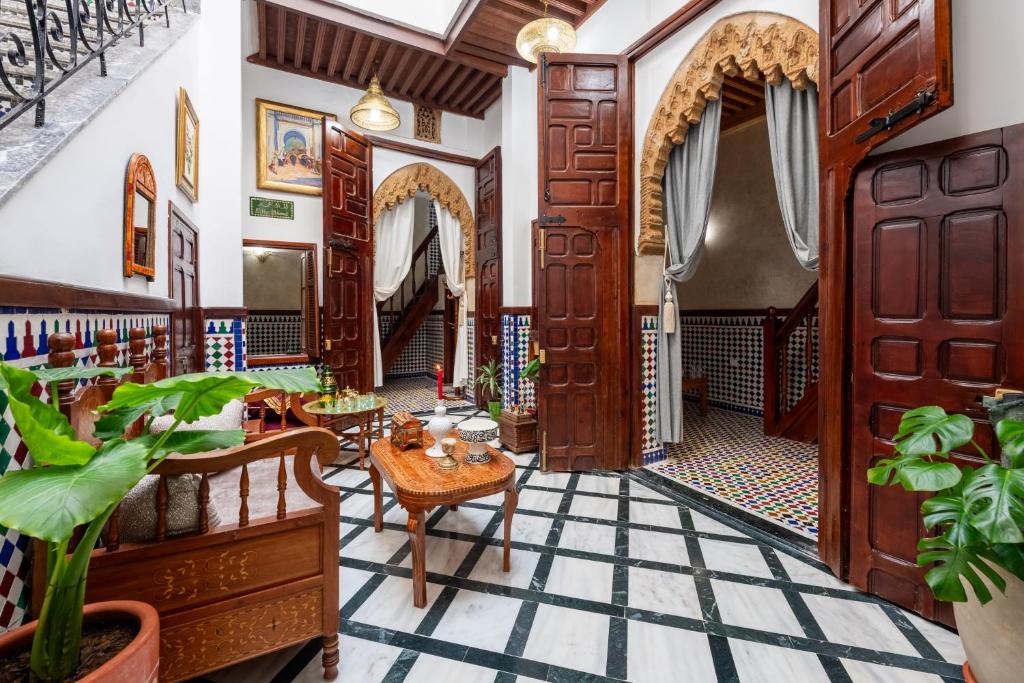 a lobby with wooden doors and tables and plants at Riad Jasmine in Rabat