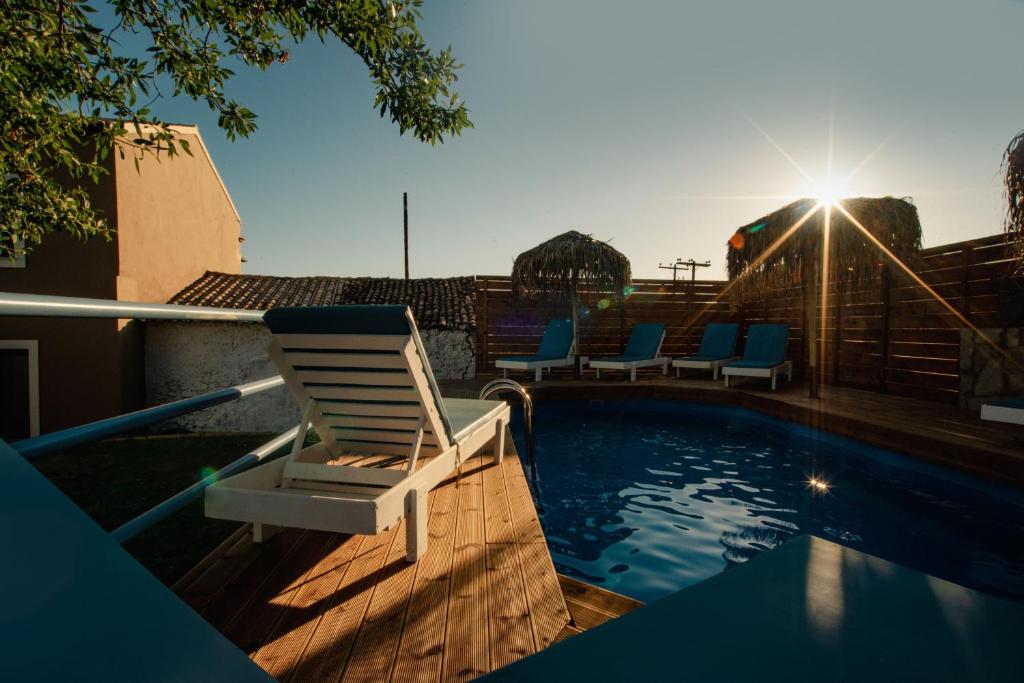 a lounge chair sitting next to a swimming pool at Villa Kalimoukos in Corfu