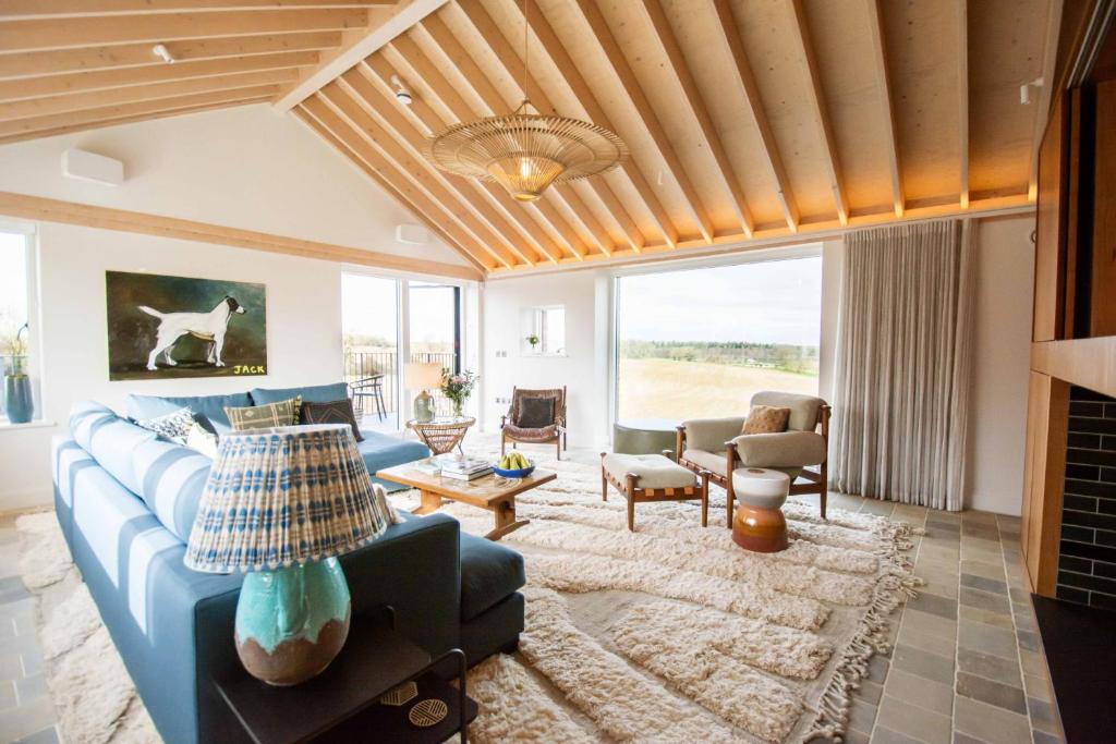 a living room with a blue couch and a table at The Barn at Manor Farm in Great Glemham