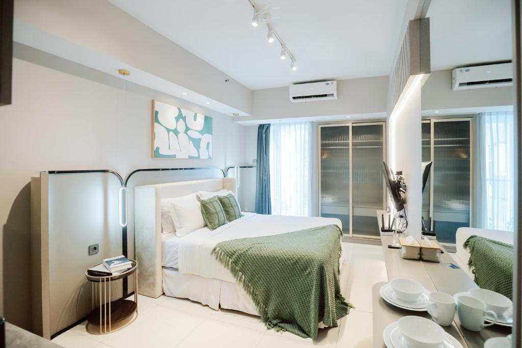 a bedroom with a bed and a living room at Yoonah at Benson Pakuwon Mall in Lontar