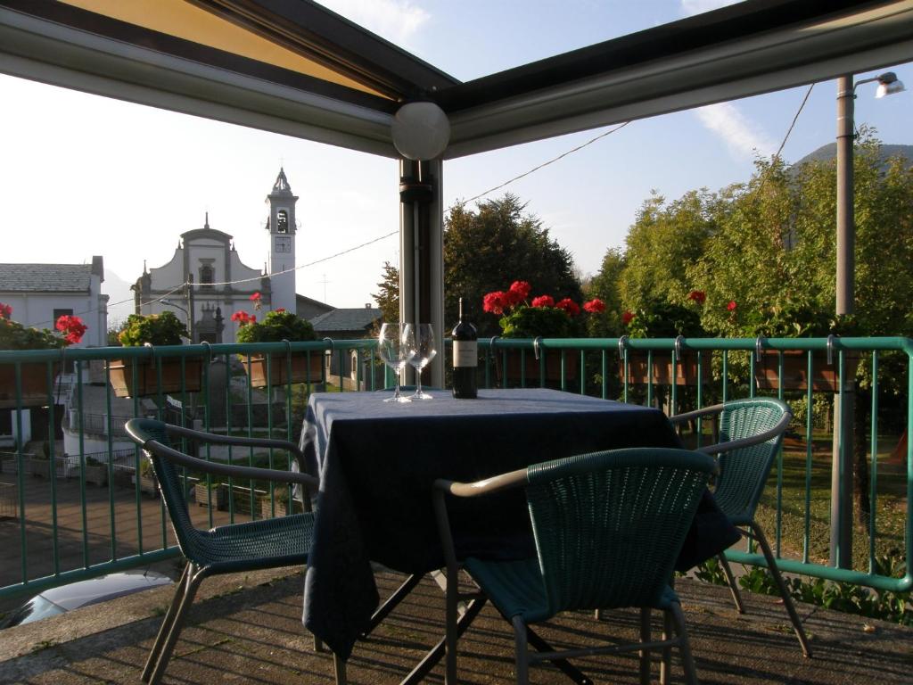 un tavolo e sedie su un balcone con torre dell'orologio. di Hotel National a Zelbio