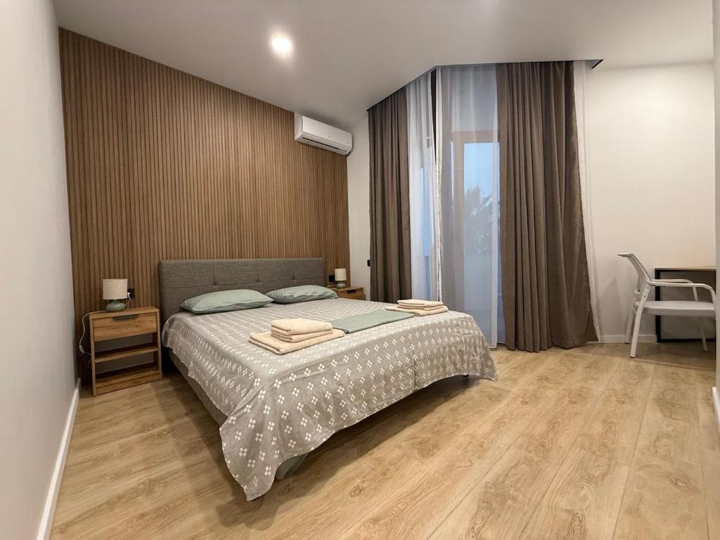 ein Schlafzimmer mit einem Bett, einem Tisch und einem Stuhl in der Unterkunft SofiCoast in Gonio