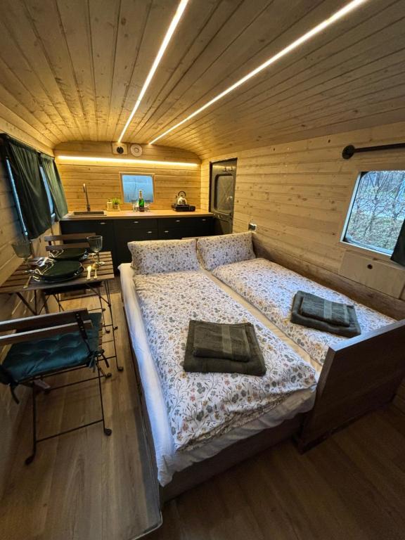 a bedroom with a large bed in a wooden room at Glamping Vejtřaska in Mochtín