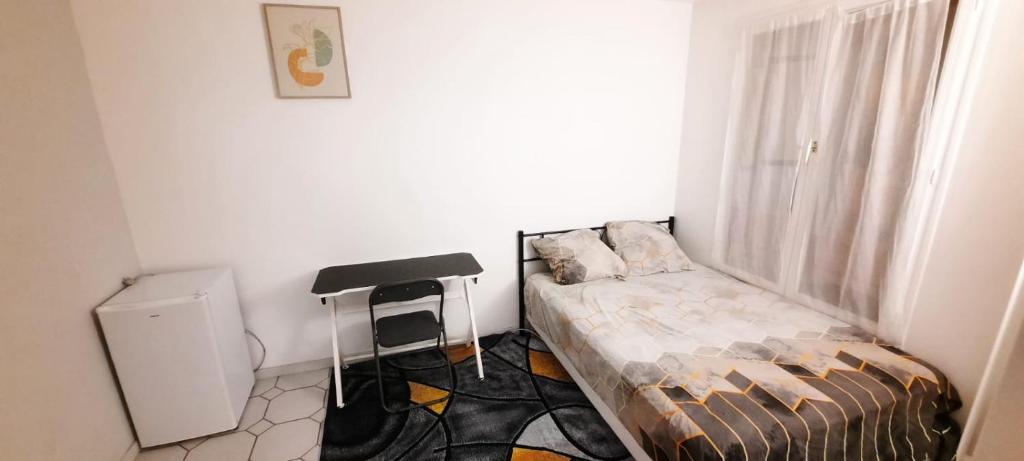 a small room with a bed and a window at Havre De Paix Réside in Le Mée-sur-Seine