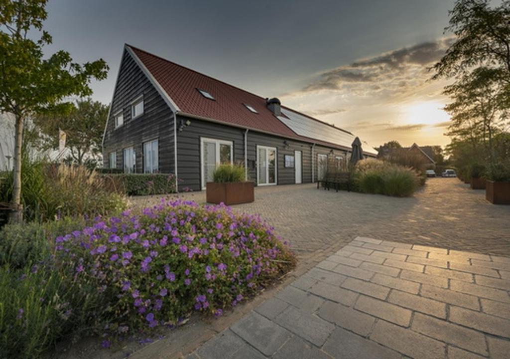 a house with purple flowers in front of it at Siblu Duinzicht in Koudekerke
