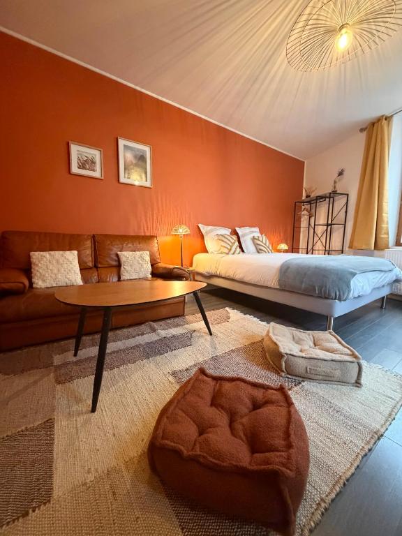a bedroom with a bed and a couch and a table at L'instant Nevers in Charleville-Mézières
