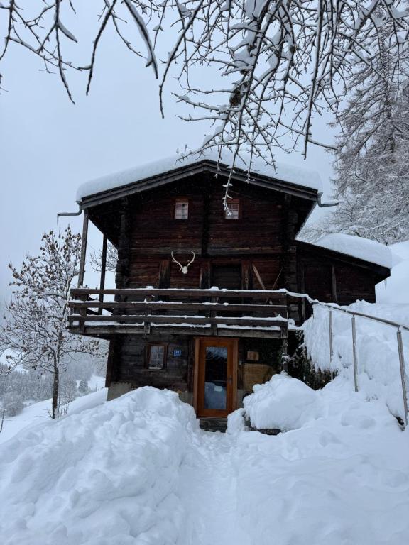 a log cabin in the snow with snow around it at Chalet in Niederwald in Niederwald