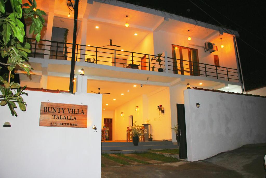 a white house with a sign that reads back then trama at Bunty Villa Talalla in Talalla South
